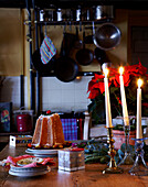 Lit candles and dessert on table of 16th Century Welsh farmhouse kitchen