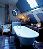 Freestanding bath under slanted roof of 16th Century Welsh farmhouse cottage