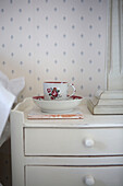Cup and saucer on painted chest of drawers