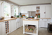 White fitted sunlit kitchen with freestanding work unit