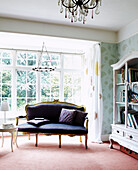 Shelving unit and upholstered sofa in sunlit window