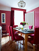 Dining table with co-ordinating pink chairs curtains and wallpaper 