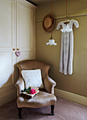 Items of clothing hang above chair with single stem rose on open book