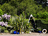 Sawn boat and plant in garden with gravel bed