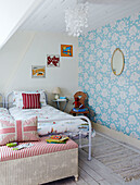 Kinderzimmer mit Blümchentapete und metallgerahmten Einzelbetten