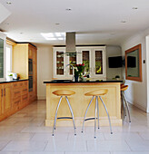 Wooden bar stools in tiled kitchen