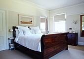 Poliertes Holzdoppelbett mit weißer Bettwäsche