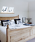 Blue and white floral motifs on wooden bed below skylight windows