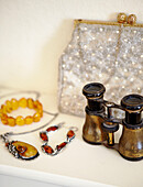 Stille life with opera glasses jewellery and vintage purse
