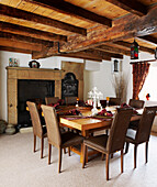 Holzbalkendecke in einem Esszimmer im Landhausstil mit Tisch und Stühlen