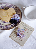 Heart shaped biscuit and cut flowers with handwritten letter