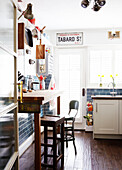 High stools at breakfast bar in tiled country kitchen