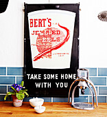 Jellied eel poster above kitchen workbench with kitchenware