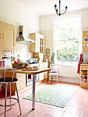 Sunlit family kitchen with bar stool at breakfast bar