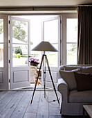 tripod floor lamp at open patio doors of country home