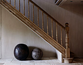 Two stone ball seats under wooden banister at staircase in country home