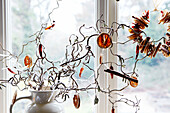 Dried orange slices and twig arrangement in jug alternative Christmas decoration