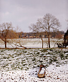 Animal trough in winter field with snowfall
