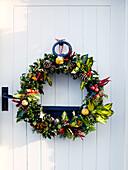 White front door with Christmas garland on exterior of country house