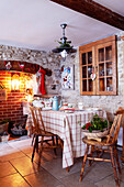 Küchentisch mit Weihnachtsstrümpfen, die am gemauerten Kamin hängen