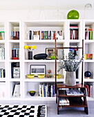 Yellow and green accent colours on shelving unit in Newcastle living room England UK