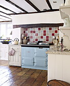 Light blue range oven in beamed kitchen of Forest Row farmhouse Surrey England UK