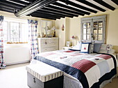 Patchworkdecke auf dem Bett in einem Zimmer mit Balkendecke Forest Row Bauernhaus Surrey England UK