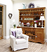 Armchair with slip cover and wooden kitchen dresser in Gateshead apartment Tyne and Wear England UK
