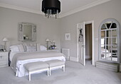 Spacious bedroom with mirrored window frames giving idea of further space country house Tunbridge Wells Kent England UK