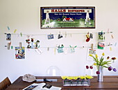 Vintage artwork and clothes line display hang above kitchen table in family home London UK