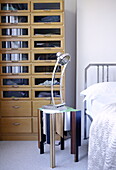 Vintage lamp on bespoke bedside table with glass fronted storage cabinet in London family home UK