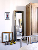 Full length vintage mirror with shoes and wardrobe in bedroom of London family home UK