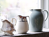 Three milkjugs on windowsill of Hexham country house Northumberland England UK
