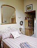 Gilt framed mirror above double bed in Hexham country house Northumberland England UK