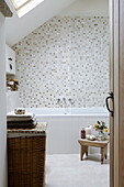 Tiled bathroom with laundry basket in Hexham country house Northumberland England UK