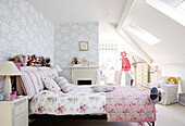 Kontrastierende Blumenmuster im Schlafzimmer eines Teenagers im Dachgeschoss eines Hauses in Harrogate Yorkshire England UK