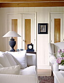 Cupboard doors with white sofas in living room of Abbekerk home in the Dutch province of North Holland municipality of Medemblik