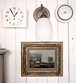 Wandleuchte mit Uhr und Barometer über einem Rahmenbild in einem Haus in Abbekerk in der niederländischen Provinz Nordholland, Gemeinde Medemblik