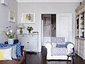 Weißer Sessel und Bücherregal im Wohnzimmer eines Londoner Hauses UK