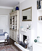 Silver mirror above fireplace with storage unit in London home UK