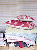Verschiedene Decken und Kissen in der Londoner Wohnung eines Textildesigners UK