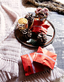 Pine cones and gift wrapped Christmas presents on bed in festive Oxfordshire home, England, UK