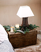 Carved wooden lamp with candles and pinecones on basket in festive Oxfordshire home, England, UK