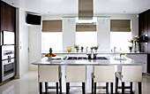 White leather bar stools in classic kitchen of luxury London home, England, UK