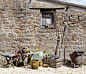 Gardening equipment outside stone cottage in rural Oxfordshire, England, UK