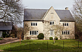Freistehendes Steinhaus in Oxfordshire mit schwarz gestrichenem Zaun, England, UK