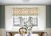 Floral patterned roman blinds at leaded dining room window of Oxfordshire home, England, UK