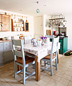 Blau gestrichene Stühle am Küchentisch in einem Landhaus in Oxfordshire, England, UK