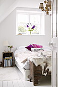 Double bed at uncurtained window with bedside crate in contemporary Oxfordshire cottage, England, UK