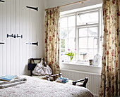 Farmhouse bedroom detail with floral curtains and tulips, Oxfordshire, England, UK